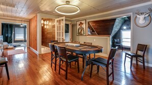 A dining area with a round table, chairs, wooden flooring, and a ceiling with exposed beams. - Casa Azul. Ideal for groups of 8+. 5 bdr / 4 bath (San Antonio)