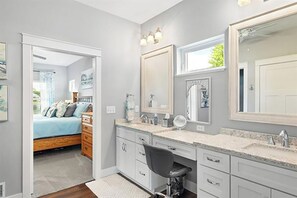 Une chambre à coucher avec un lit, une commode et un grand miroir.