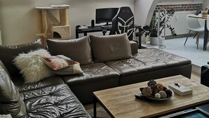 A modern loft apartment with a leather sofa, a gaming chair, a dining table, and skylights. - Bail Mobilité, Grand Loft hypercentre de Lille (Lille)