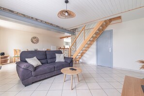 Ein Wohnzimmer mit einer Couch, einem Couchtisch und einer Treppe.
