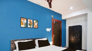 A bedroom with a bed, a wardrobe, a door, and ceiling fan. - Hotel O Noonmati Guwahati (Guwahati)