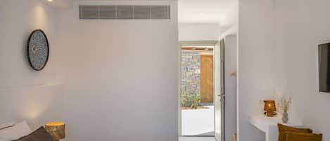 Un dormitorio moderno con una cama grande, lámparas de noche, un reloj en la pared y vistas al exterior.