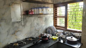 A kitchen with a gas stove, pots, and a window with blinds. - Affordable Cozy Stay for Families Budget friendly (Kommaghatta)