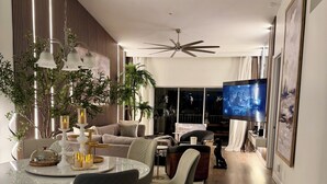 A modern living room with a dining area, a ceiling fan, and a flat-screen TV. - Perfect Snowbird Retreat – Sunny Condo Near Pool & Clubhouse (Naples)
