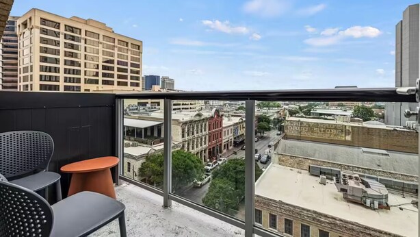 A balcony with a view of a cityscape, including buildings and a street. - Lively 2 BR Apt Downtown ATX (Austin)