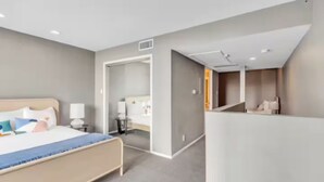 Una habitación de hotel moderna con cama, mesitas de noche, escritorio y una silla.