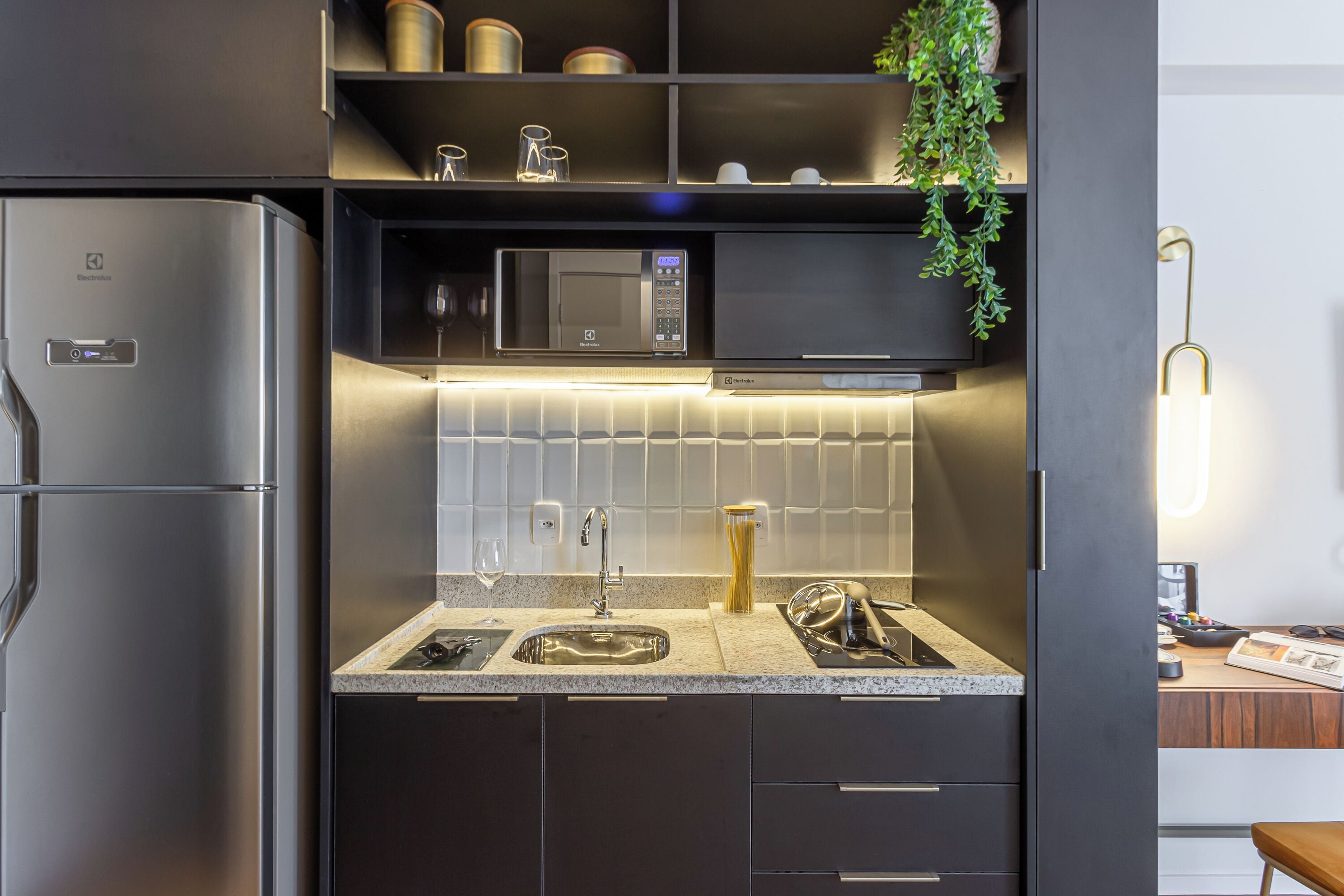 Una cocina moderna con refrigerador, microondas y pileta incorporados.