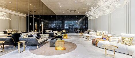 Una sala de estar lujosa con techos altos, muebles modernos y un amplio ventanal.