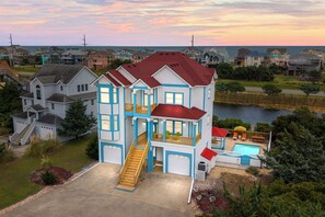 Ein zweistöckiges Haus mit Balkon, Treppe und Schwimmbad.
