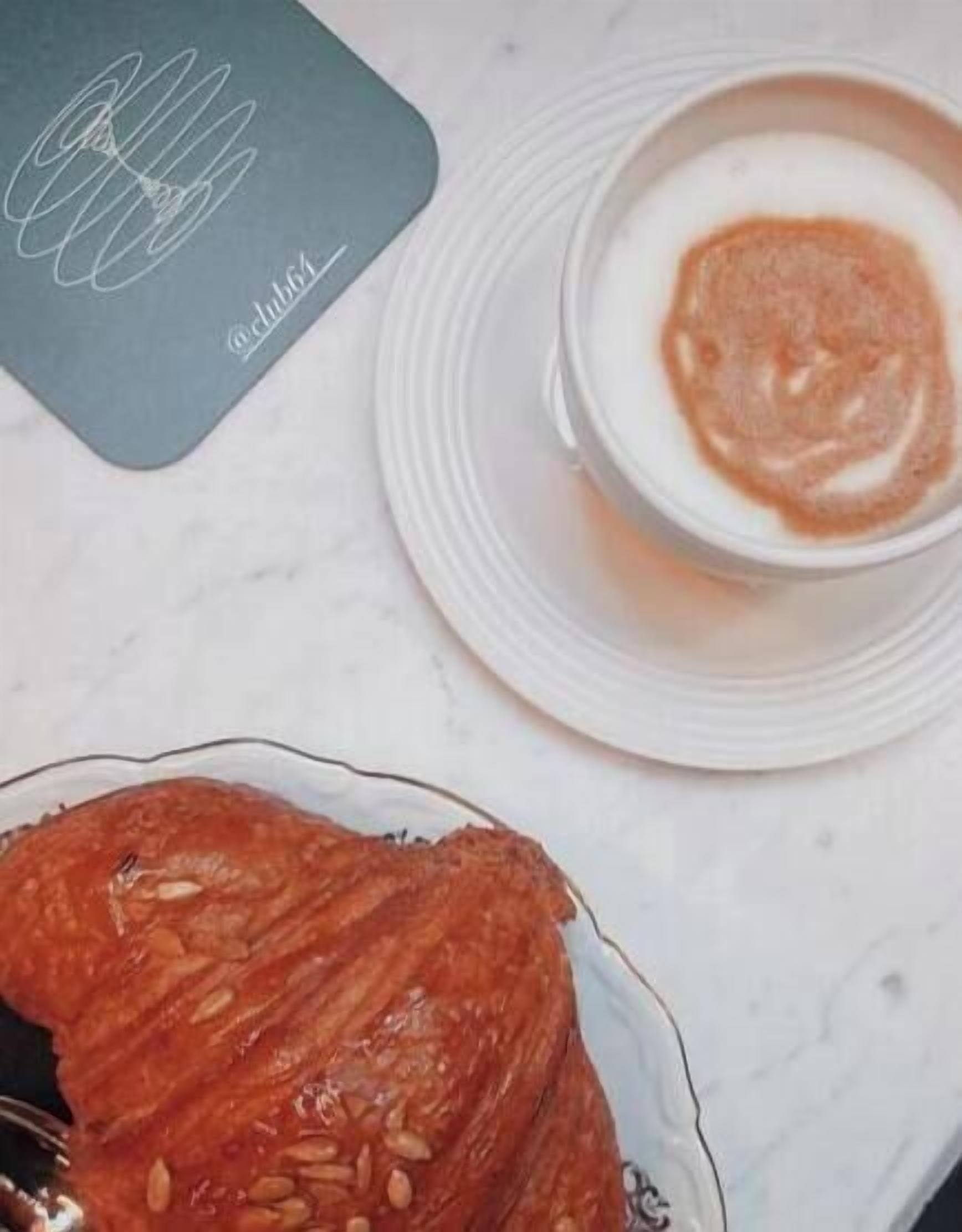 A table with a plate of food, a cup of coffee, and a menu.