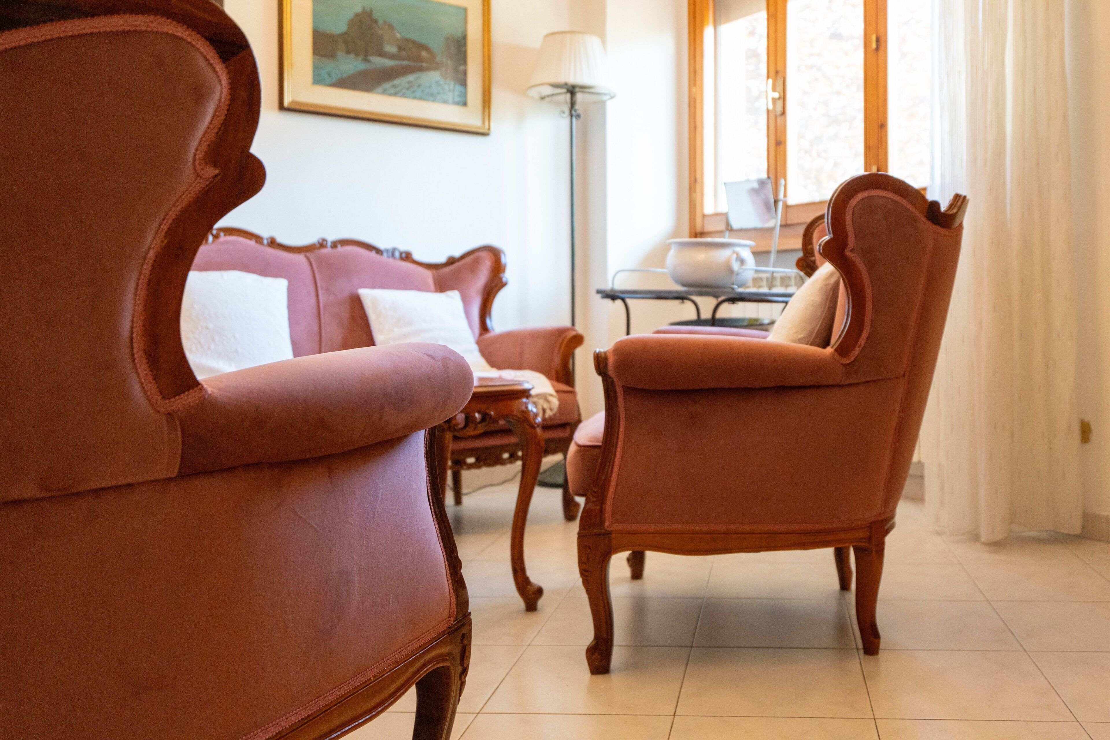 Quarto com sofá, poltrona e mesa com luminária.