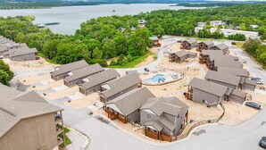 Un quartier résidentiel avec des maisons, une piscine et un lac en arrière-plan.
