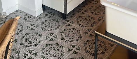 A kitchen with a stove, oven, and patterned floor tiles.