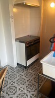 Una cucina con piano cottura, forno e pavimento con piastrelle decorate.