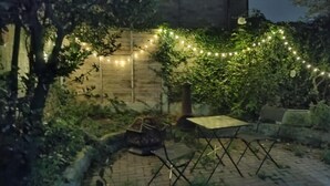 An outdoor patio area with a brick floor, a small table, and chairs. - House Sleeps 6 With Garden and Parking (Leeds)