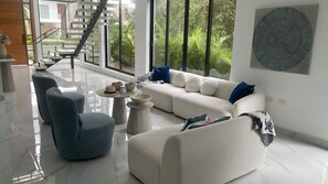 Ein modernes Wohnzimmer mit einem weißen Sofa, blauen Sessel und einem Couchtisch.
