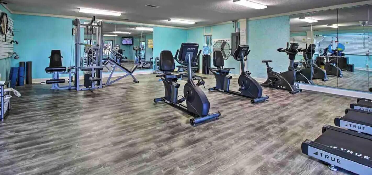 A free gym with exercise equipment and a large mirror.