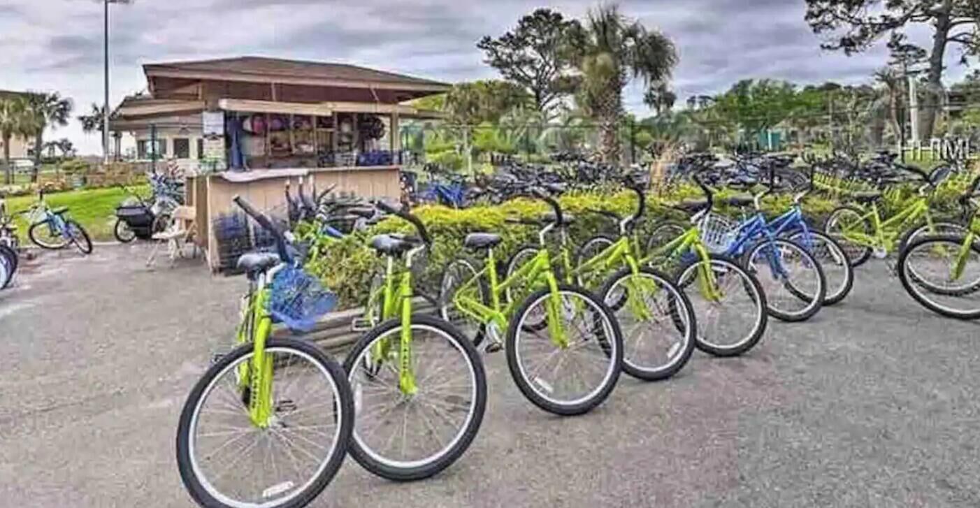 A row of bicycles parked in front of a building with a covered seating area.