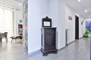 Ein Flur mit einem dunklen Holzschrank, einem Heizkörper und einer grünen Vase.