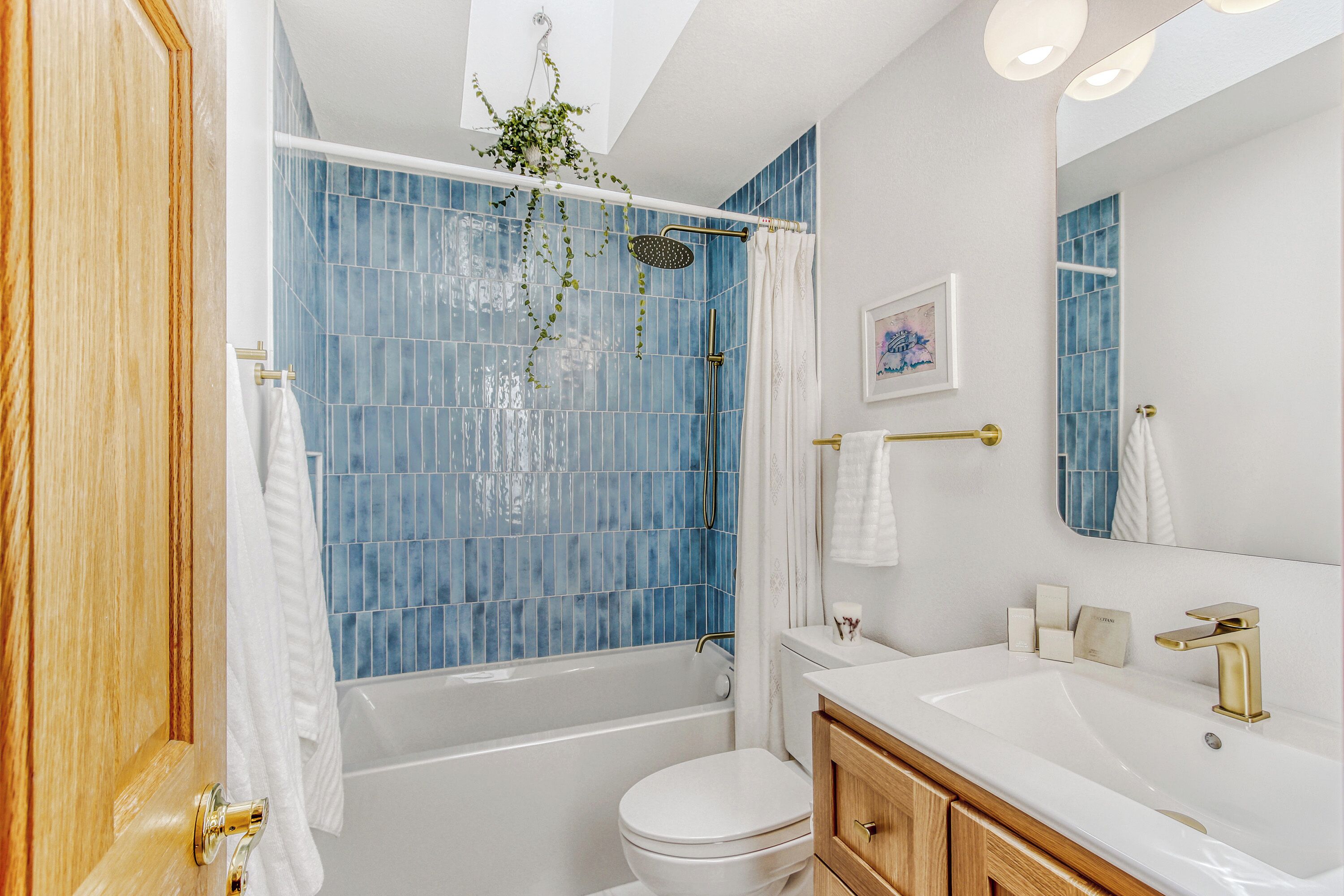 Une salle de bain équipée d’une baignoire, de toilettes et d’un meuble-lavabo avec un miroir.