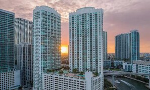 De hauts immeubles avec un coucher de soleil en arrière-plan.