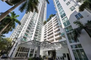 A high-rise building with multiple floors, large windows, and a modern architectural design. - > Amazing NEW Remodeled LOFT < (Miami)