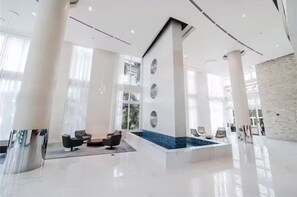 A spacious lobby with a pool, large windows, and modern furniture. - > Amazing NEW Remodeled LOFT < (Miami)