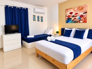 A hotel room with a bed, a TV, a desk, and a painting on the wall. - Sol Caribe Sleep&Go (Punta Cana)