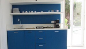 Eine Küche mit blauen Schränken, einer weißen Arbeitsplatte und einer Kaffeemaschine.