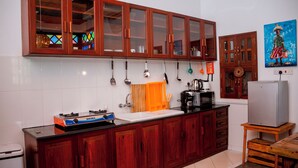 Una cocina con armarios de madera, microondas, fregadero y refrigerador.