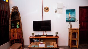 Una habitación con televisión, muebles de madera, un globo terráqueo y un cuadro.