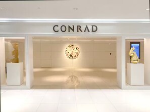 A CONRAD store with a minimalist design, featuring a central circular light installation and two sculptures on either side. - ★@ EXCLUSIVE Large Luxury Water View FREE Parking★ (Miami)