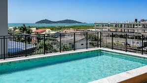A swimming pool with a view of the sea and a distant island.