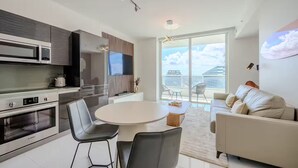 Eine moderne Küche mit Essbereich, einer Couch und einem Balkon mit Blick auf die Stadt.