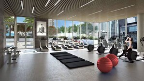 Ein modernes Fitnessstudio mit Laufbändern, Crosstrainern und Kurzhanteln.