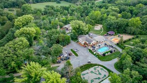 An aerial view of a residential area with a large house, a swimming pool, and a golf course. - Baraboo RV Resort (Baraboo)