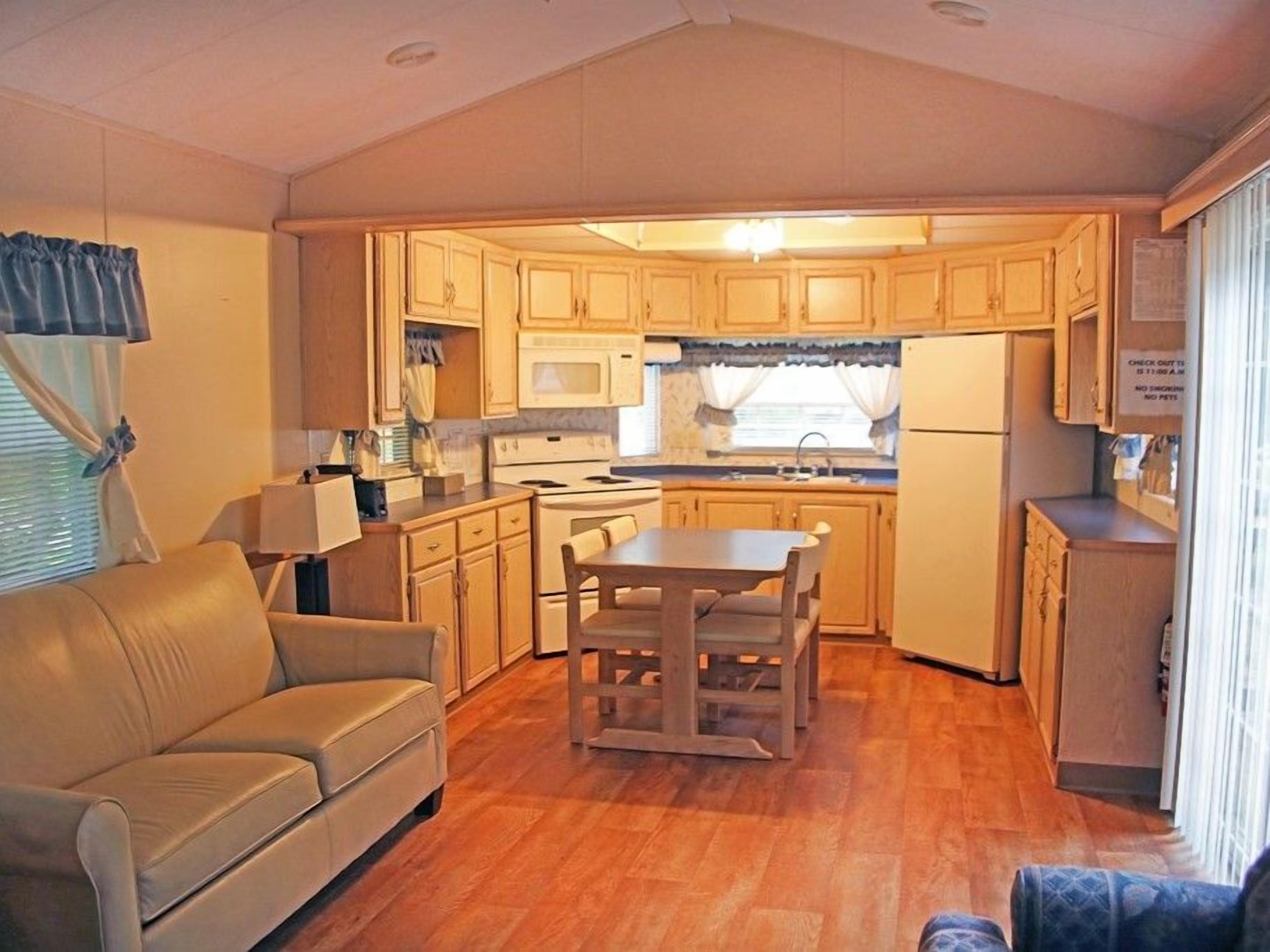 A compact living space with a kitchenette, a dining table, and a sofa.