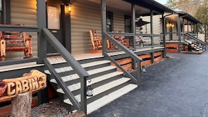A cabin with a porch, wooden steps, and a sign labeled 'CABIN.' - Natural State Cabins - 5 Cabin Listing (Hot Springs)