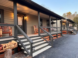 A cabin with a porch, wooden steps, and a sign labeled 'CABIN.' - Natural State Cabins - 5 Cabin Listing (Hot Springs)