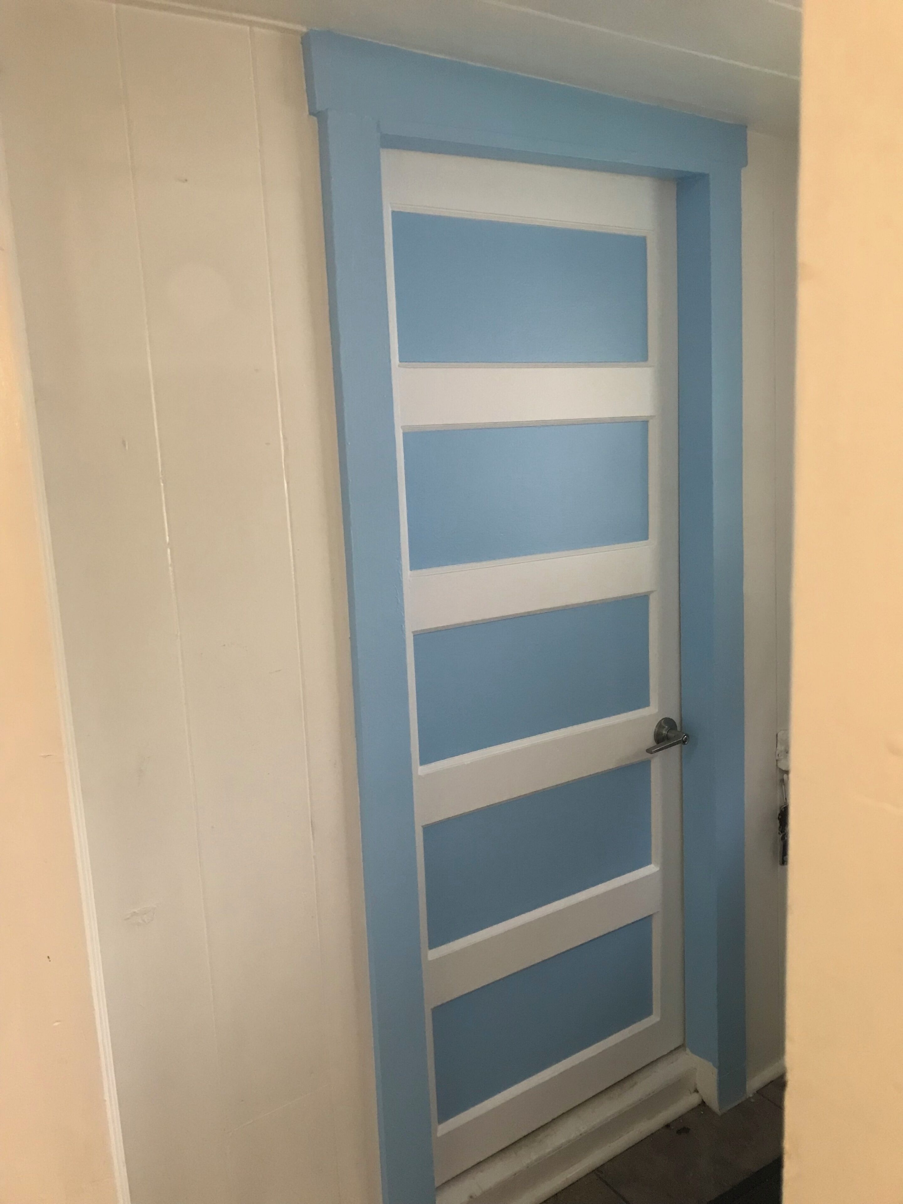 A door with a white frame and blue panels.