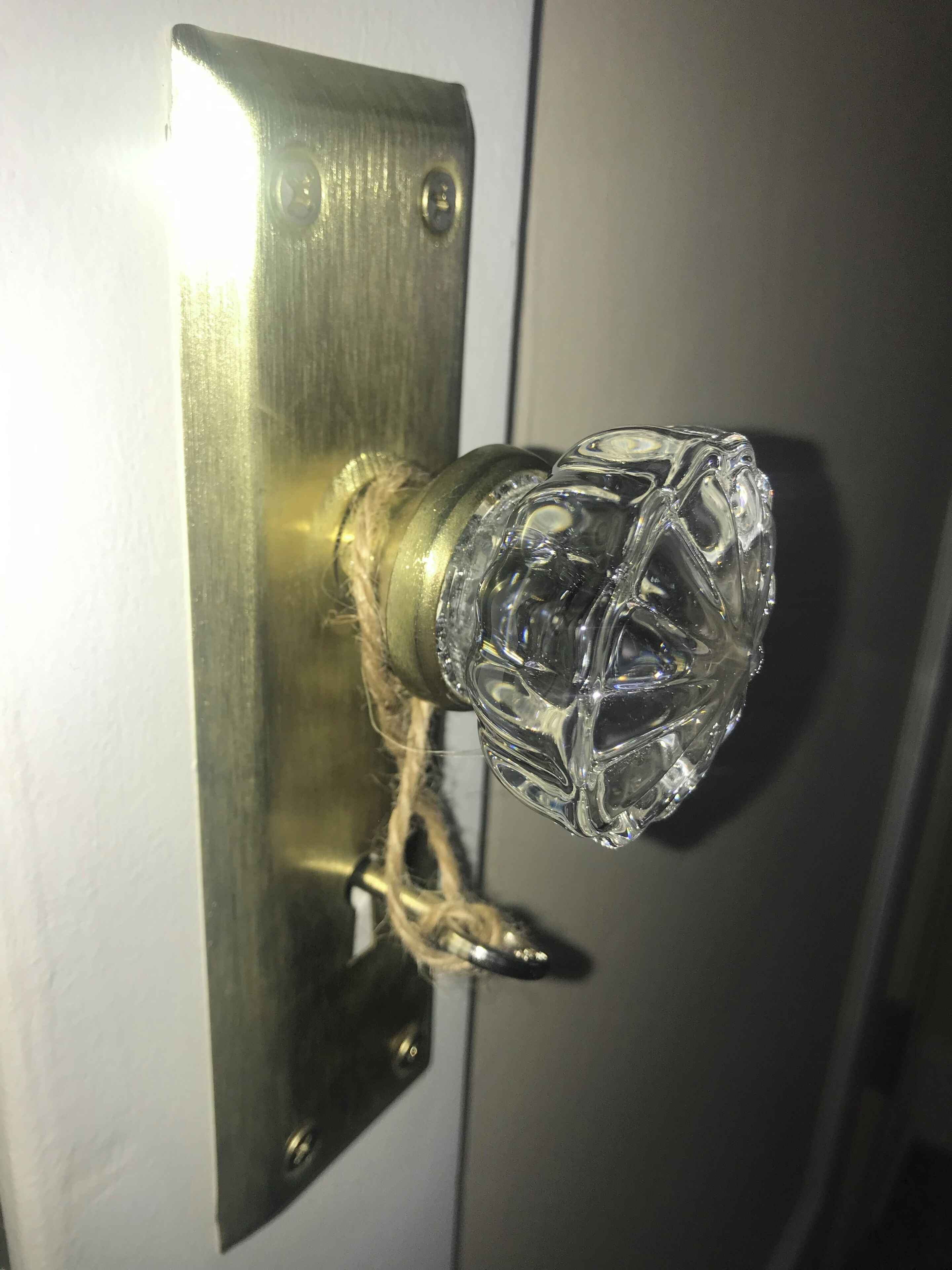 Een deur met een messing handvat en een glazen knop.