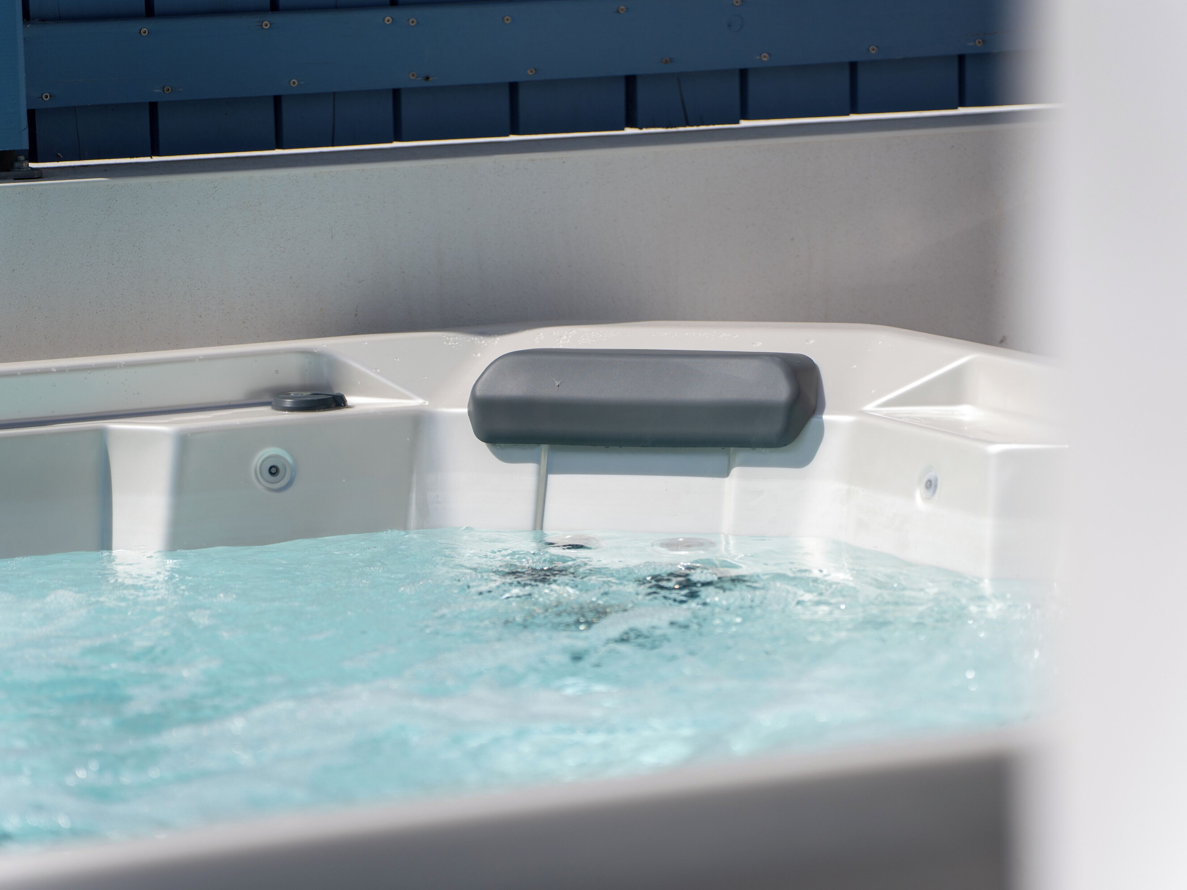 A hot tub with a control panel and water flowing out.