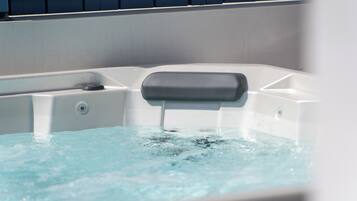 A hot tub with a control panel and water flowing out.