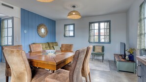 A dining area with a wooden table, leather chairs, and woven pendant lights. - Bains de Mer House & Jacuzzi steps from the beach, Walk to town, Sleeps 6 (Saint-Gilles-Croix-de-Vie)