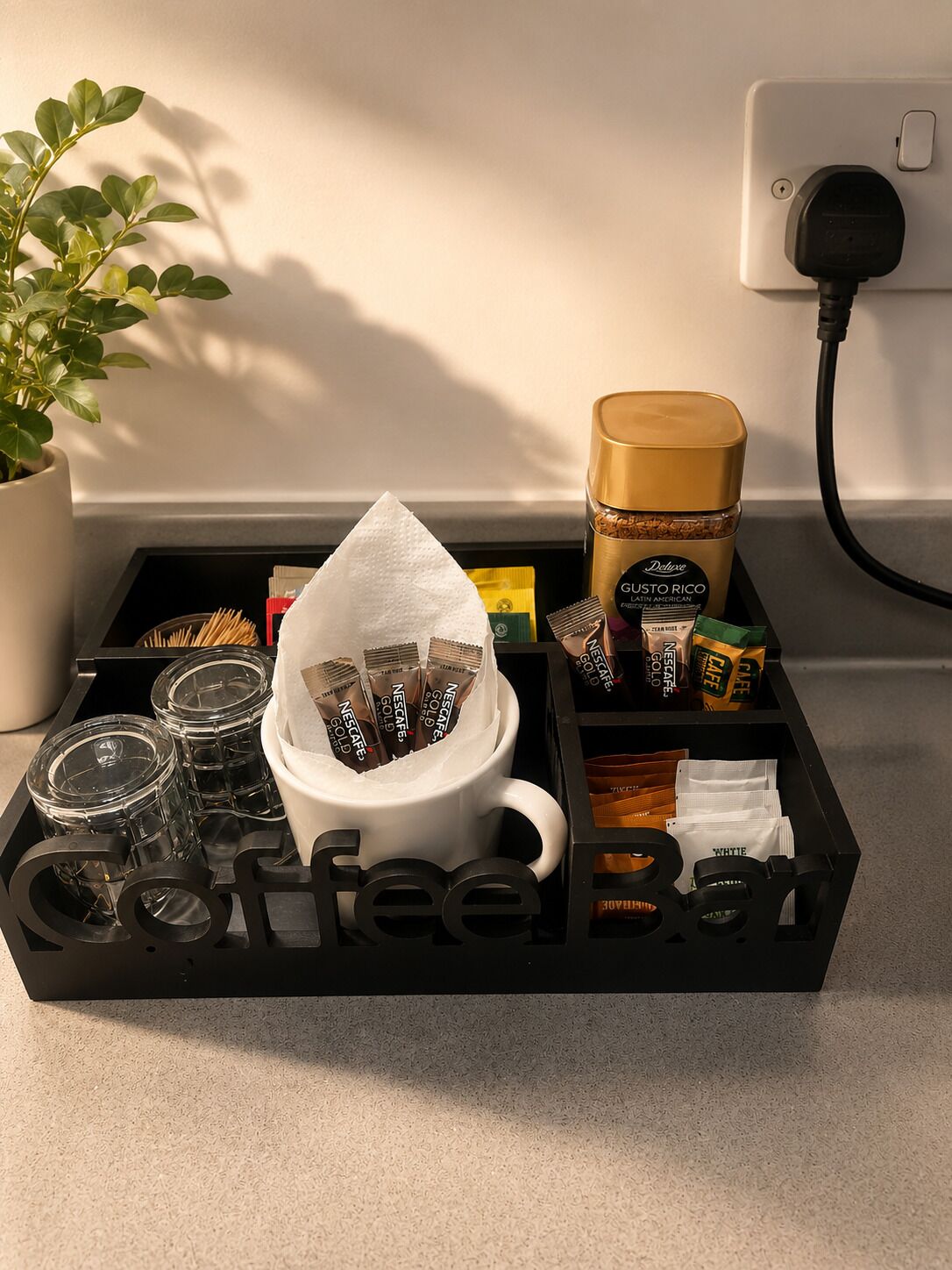 A coffee station with a white mug, a coffee grinder, and various coffee pods.
