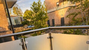 A balcony with a green chair, a potted plant, and a candle. - Stylish 2-Bed Apt 
| 10 Mins to Oxford Universities/city | Free private parking (Oxford)