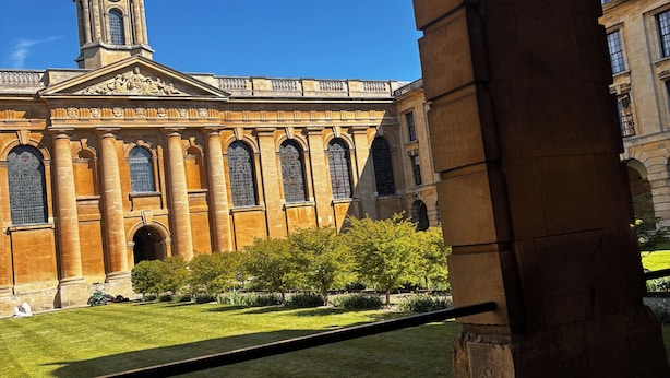 A historic building with a prominent clock tower, arched windows, and a well-maintained lawn. - Stylish 2-Bed Apt 
| 10 Mins to Oxford Universities/city | Free private parking (Oxford)