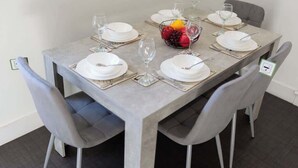 A dining table set for six with white plates, cutlery, and a fruit bowl. - Balmoor House - 4 Beds in Peterhead near the coast (Aberdeenshire)
