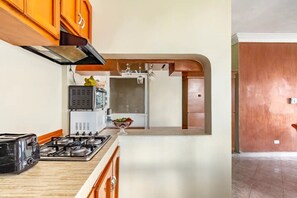 Eine Küche mit Gaskochfeld, Toaster, Mikrowelle und Kühlschrank.