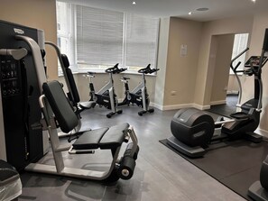 Ein Fitnessstudio mit Cardiogeräten, Gewichten und Laufbändern.